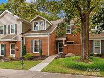 Charming brick townhome featuring a well-manicured lawn and inviting entrance at 9473 Kings Falls Dr, Charlotte, NC 28210