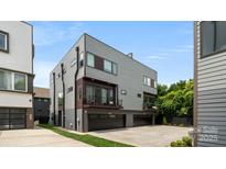 Modern gray home featuring a two-car garage, balcony, and clean architectural lines at 1011 Westbrook Dr # A, Charlotte, NC 28202