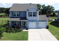 Charming two-story home with a two-car garage, well-maintained lawn, and beautiful landscaping at 1019 Beacon Ave, Monroe, NC 28110