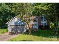 Charming home with a mix of brick and siding and a well-maintained front yard and mature trees at 10925 Lassen Ct, Charlotte, NC 28214
