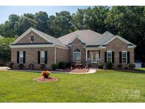 Charming brick home with well-manicured lawn, garden and mature trees at 126 Doyle Farm Ln, Mooresville, NC 28115