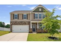 Charming two-story home featuring stone accents, a two-car garage, and a well-manicured front lawn at 128 Cherry Birch St, Mooresville, NC 28117