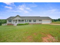 Charming single-story home features a welcoming front porch and attached two-car garage, set on a large landscaped lawn at 308 Laurel Ridge Dr, Lincolnton, NC 28092