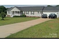 Charming single-story home featuring a long driveway, well-manicured lawn, and an attached garage at 308 Laurel Ridge Dr, Lincolnton, NC 28092