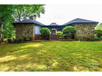 Charming stone-clad house featuring a lush front lawn, mature trees, and brick steps leading to the entrance at 4275 Herman Sipe Rd, Conover, NC 28613