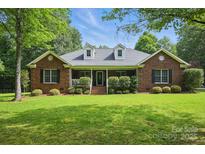 Charming brick home with well-manicured lawn and inviting front porch, complemented by lush green landscaping at 4824 Waxhaw Farms Rd, Waxhaw, NC 28173