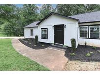 Charming home featuring white siding, a black front door, and beautifully landscaped front yard at 6310 Forney Hill Rd, Denver, NC 28037