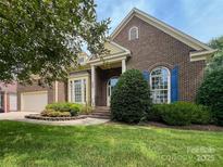 Beautiful brick home featuring a well-manicured lawn and charming architectural details and a two-car garage at 6507 Fairway Point Dr, Charlotte, NC 28269