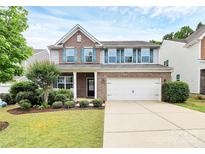Two-story home featuring brick and gray siding, a two-car garage, well-maintained lawn and landscaped front yard at 6961 Liverpool Ct, Fort Mill, SC 29707