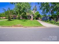 Charming single-story home with lush green lawn and mature trees shading the front yard at 823 Yuma St, Charlotte, NC 28213