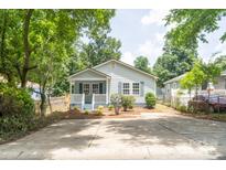 Charming home with a quaint front porch, a well-maintained yard, and a spacious driveway at 830 Mcarthur Ave, Charlotte, NC 28206