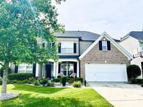 Charming two-story home featuring well-manicured lawn, brick accents, and attached two car garage at 9792 Nw Ravenscroft Nw Ln, Concord, NC 28027