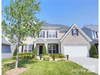 Charming two-story home with brick and siding exterior, manicured lawn, and well-maintained landscaping at 9792 Ravenscroft Nw Ln, Concord, NC 28027