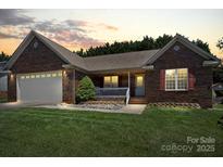 Charming brick home featuring an attached garage and inviting front porch at 1011 Atherstone Nw St, Conover, NC 28613
