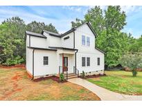 Charming two-story home featuring white siding, black accents, landscaped yard, and a welcoming walkway at 1011 Sandy Ct, Gastonia, NC 28056