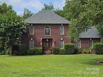 Charming brick two-story home featuring manicured lawn and traditional architectural details at 103 Northchase Dr, Concord, NC 28027