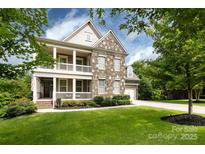 Charming two-story home boasting a stone facade, inviting porch, and well-manicured front lawn at 14010 Promenade Dr, Huntersville, NC 28078