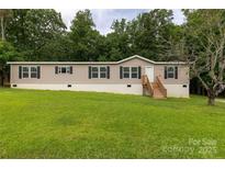 Inviting single Gathering home featuring a manicured lawn with a wooden porch and black shuttered windows at 159 Blackmon Pond Rd, Lancaster, SC 29720