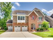 Beautiful brick and stone two-story home with three-car garage and well-manicured lawn at 169 Halifax Dr, Fort Mill, SC 29707