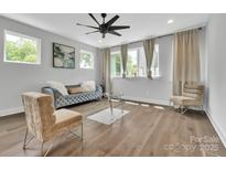 This living room features beautiful hardwood floors, a modern fan, and a comfortable couch at 1933 W Trade St, Charlotte, NC 28216