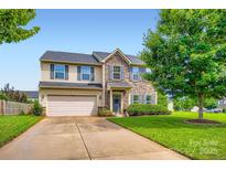 Charming two-story home with stone accents, a well-manicured lawn, and an attached two-car garage at 5056 Crandon Rd, Fort Mill, SC 29707
