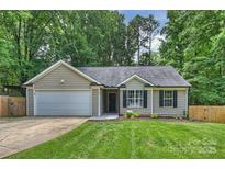 Charming single-story home with a well-manicured lawn, attached garage, and beautiful landscaping at 5179 Poplar Glen Dr, Matthews, NC 28104