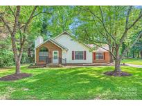 Charming home with a brick and siding exterior, manicured lawn, and mature trees in a serene setting at 5817 Rocky Mount Ct, Charlotte, NC 28214