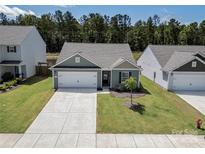 Charming single-story home with a well-maintained front lawn and a two-car garage on a sunny day at 672 Lamorak Pl, Richburg, SC 29729
