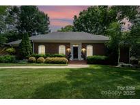 Charming one-story brick home featuring a beautifully landscaped yard and a welcoming front entrance at 935 Trentle Ct, Charlotte, NC 28211