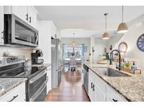 Bright kitchen featuring granite countertops, stainless steel appliances, and an open layout to the dining area at 103 Blackstone Ct # C, Statesville, NC 28677