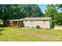 Charming single-story home featuring a covered porch and a well-maintained lawn surrounded by lush trees at 121 C & K Dr # 60, Taylorsville, NC 28681