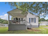 Charming home features a covered front porch with a swing and blue shutters at 123 E Farmview St, Gastonia, NC 28054