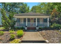 Charming single-story home with a covered porch, landscaped yard, and blue siding at 1500 Pecan Ave, Charlotte, NC 28205