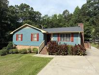 Charming one-story home featuring red shutters and manicured landscaping on a verdant, tree-lined lot at 200 Breslin St, Wadesboro, NC 28170