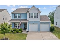 Charming two-story home with a well-manicured lawn and a two-car garage at 214 Hidden Lakes Rd, Statesville, NC 28677