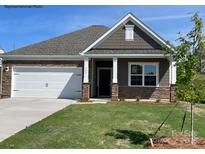 Charming single-Gathering home featuring stone accents, a two-car garage, and a well-manicured lawn at 235 Parker Claire Ln, Kings Mountain, NC 28086