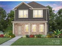 Charming two-story home featuring a brick facade, complemented by a well-manicured lawn and inviting landscaping at 3633 Edisto Pl # 118, Monroe, NC 28110