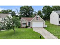 Charming one-story home featuring a well-manicured lawn and an attached two-car garage, enhancing curb appeal at 406 Courtland Ct, Kannapolis, NC 28081
