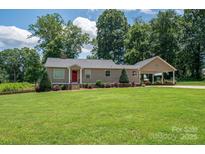 Charming home featuring a well-manicured lawn and a welcoming red front door, complemented by a convenient carport at 4441 Jim Wise Rd, Lincolnton, NC 28092
