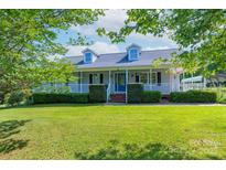 Charming home with a welcoming front porch and well-manicured lawn and blue door at 5211 Spring Gln, York, SC 29745