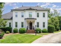 Stately two-story painted brick home with well manicured landscaping and covered front porch at 5537 Challis View Ln, Charlotte, NC 28226