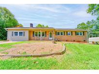 Charming brick home featuring a cozy front porch and lush green lawn at 701 Mcswain Rd, Shelby, NC 28150