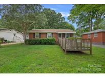 Charming single-story brick home with a well-maintained front lawn and handicap accessible ramp at 807 Claremont Rd, Charlotte, NC 28214