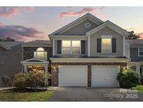 Charming two-story home with attached two-car garage and well-maintained landscaping at twilight at 9511 Turning Wheel Dr, Charlotte, NC 28214
