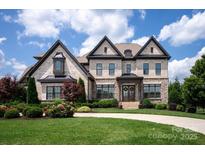 Stunning two-story brick home featuring a well-manicured front yard and a classic architectural design at 11008 Strike The Gold Ln, Waxhaw, NC 28173