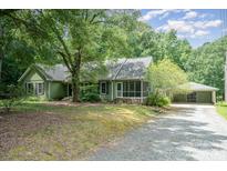 Charming single-story home featuring a screened porch and a detached two-car garage at 114 Larkfield Dr, Waxhaw, NC 28173