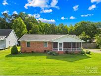 Charming brick ranch home with a screened porch and lush green lawn at 13715 Mayes Rd, Huntersville, NC 28078