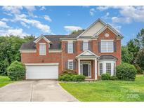 Charming two-story brick home with a well-manicured lawn and a two-car garage at 14911 Taggert Trail Dr, Charlotte, NC 28273