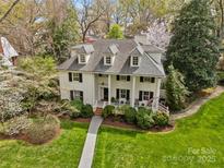 Stunning two-story home featuring a manicured lawn, dormer windows and lush landscaping creating an inviting curb appeal at 1579 Queens W Rd, Charlotte, NC 28207