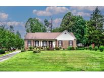 Charming single story brick home with a well-manicured lawn and mature trees at 1658 Buckingham Ave, Gastonia, NC 28054